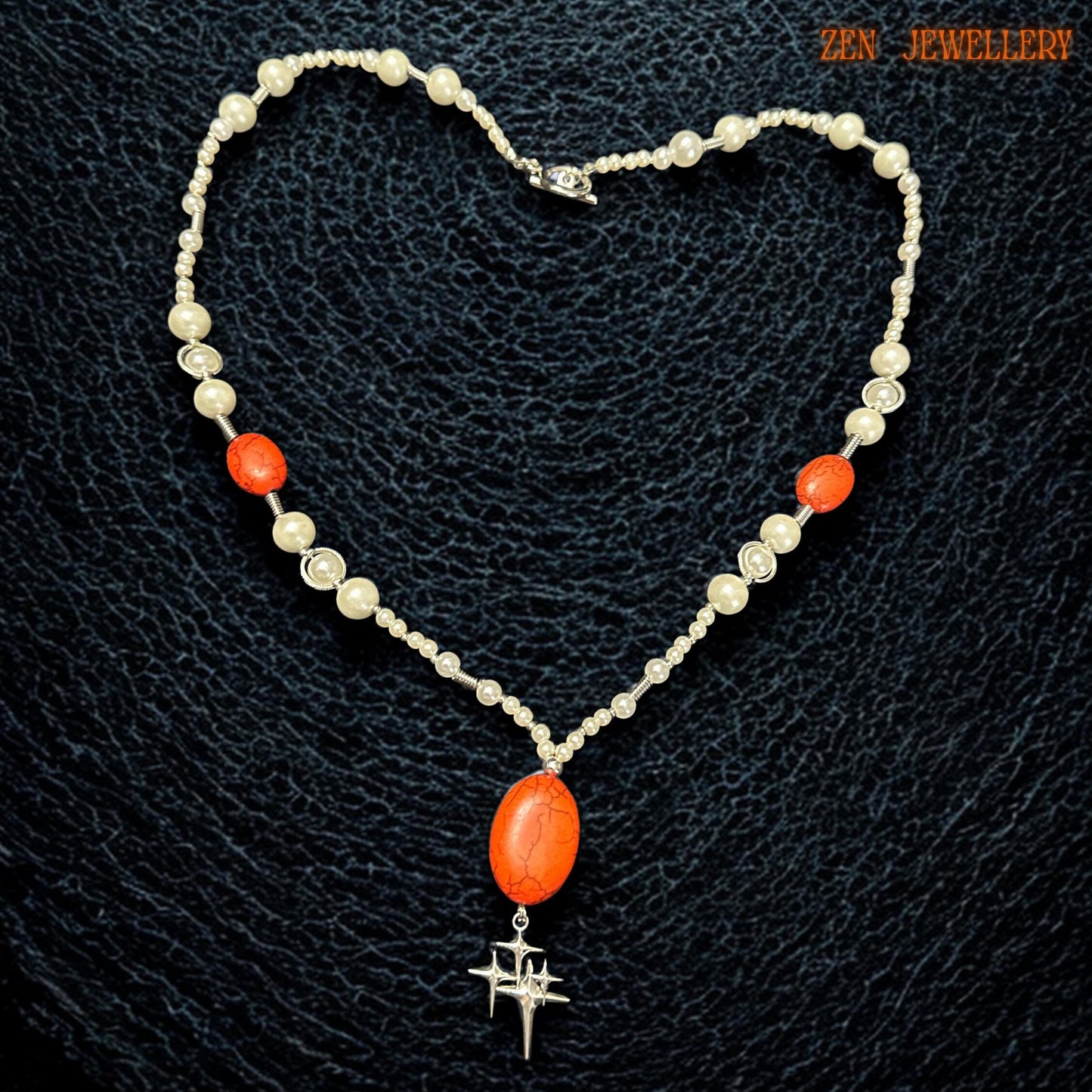 Elegant coral and pearl statement necklace photographed on a model showing the graceful Y-shaped drop design that elongates the neckline beautifully. The creamy white pearl-style beads add vintage elegance while the vivid coral-red gemstones create warmth and visual impact suitable for romantic boho styling and special occasion wear.