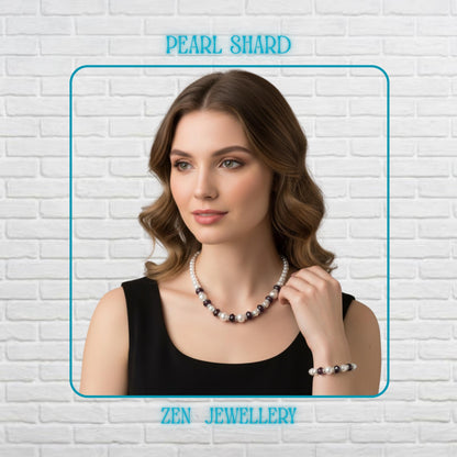 This handmade white pearl necklace and bracelet set features glossy pearl-style beads combined with sparkling purple crystal accents and silver rhinestone spacers. The jewellery is displayed on a model that highlights the elegant contrast between the soft white pearls and shimmering crystal details. The necklace and bracelet have a delicate layered design with small round pearls and larger accent beads arranged for texture and balance.