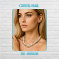 Elegant handmade white pearl necklace and bracelet set displayed on a black textured background featuring glossy round pearl-style beads combined with sparkling faceted crystal beads and silver chain closures. The necklace forms a circular shape with crystal drop accents at the front centre while the matching bracelet sits inside the necklace for a coordinated bridal jewellery look. The soft white pearls reflect light beautifully and create a tim