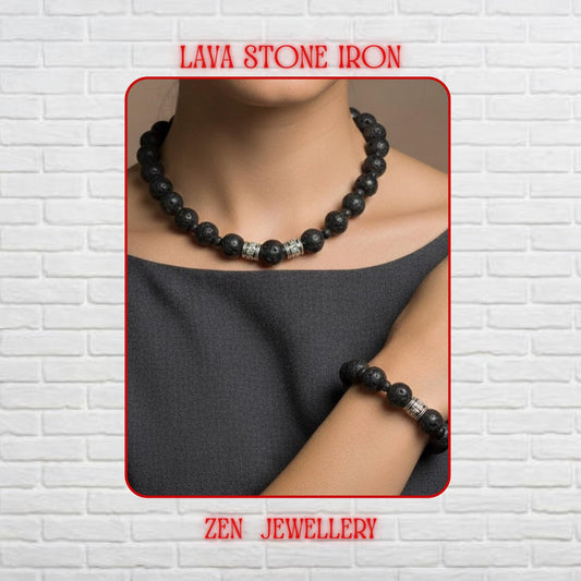 Handmade black lava stone necklace and bracelet set displayed on a rich red textured background with elegant silver artisan spacers. The volcanic beads feature a porous matte texture with natural organic details that create a bold and grounding appearance. The necklace combines multiple bead sizes for visual balance and includes a silver clasp with an extension chain and a delicate star charm.