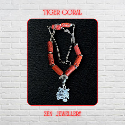 Close-up image of a genuine coral necklace featuring vibrant red coral tube beads with organic natural textures and black inclusions. Silver rhinestone spacer beads add sparkle between the coral sections while the polished silver tiger pendant creates a fierce and symbolic centrepiece. The silver chain sides provide flexibility and modern contrast. Necklace measures approximately 58 cm or 22.8 inches long.