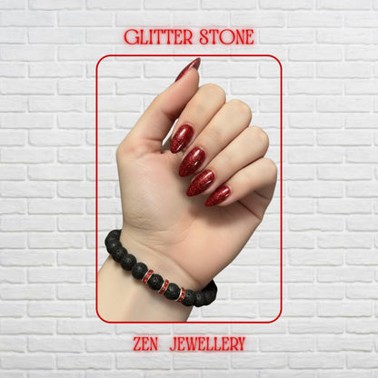 Handmade black lava stone bracelet with bright red rhinestone spacer accents creating elegant contrast. The bracelet features porous volcanic beads with matte texture and mixed bead sizes for a natural handmade appearance. The red crystal spacers add subtle sparkle and vibrant colour against the dark lava stones. Bracelet size is approximately 17 cm with comfortable stretch fit for everyday wear.