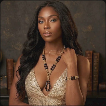 beautiful model presents the golden necklace and bracelet onyx set